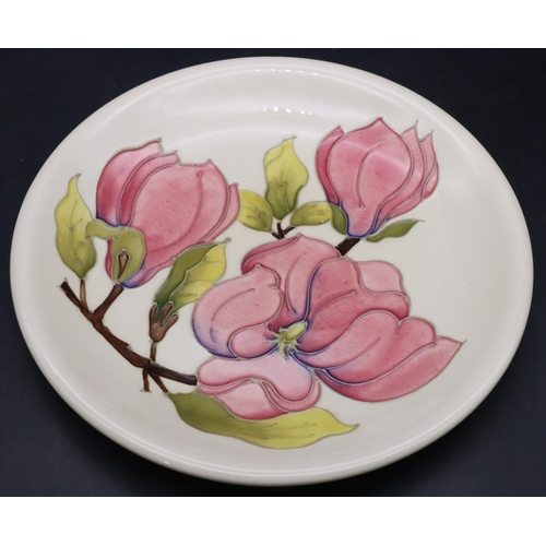 25 - A Moorcroft round plate on cream ground with pink and green floral and leaf decoration