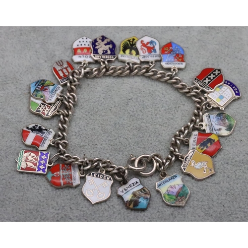 317 - A silver bracelet mounted with 19 silver and enamelled shield shaped charms, 29.5 grams gross