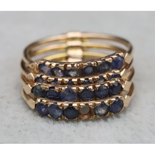 323 - A set of 4 entwined gold rings, each set with 6 blue stones (1 stone missing), Size O, 4.7 grams gro... 