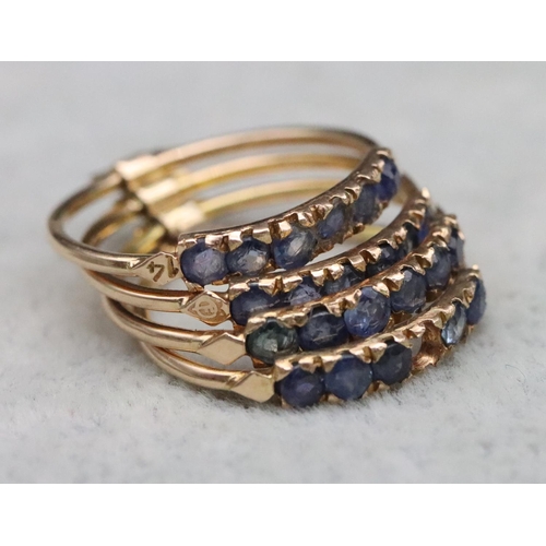 323 - A set of 4 entwined gold rings, each set with 6 blue stones (1 stone missing), Size O, 4.7 grams gro... 