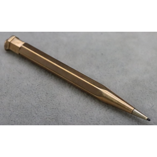 338 - A 9ct gold propelling hexagonal shaped pencil with engine turned decoration