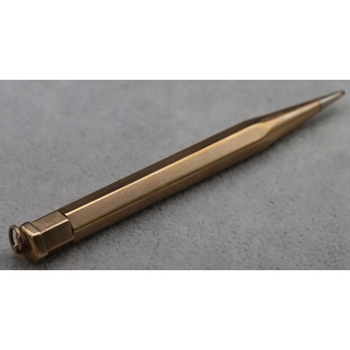 338 - A 9ct gold propelling hexagonal shaped pencil with engine turned decoration