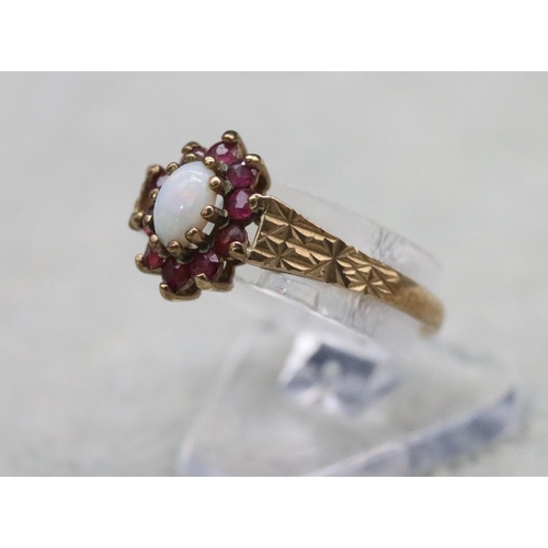 372 - A 9ct gold oval ring set with opal surrounded by garnets, Size N, 1.4 grams gross