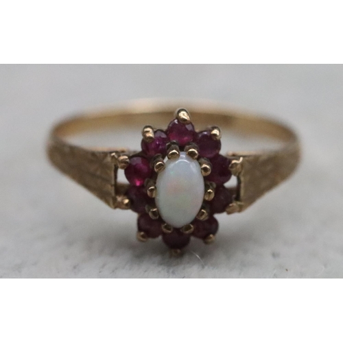 372 - A 9ct gold oval ring set with opal surrounded by garnets, Size N, 1.4 grams gross