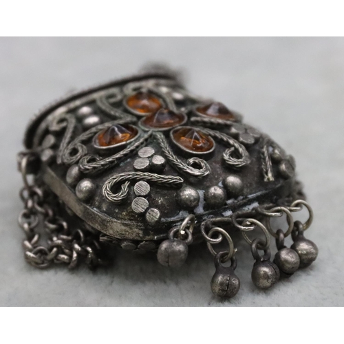 389 - An Eastern silver coloured metal lidded pot mounted with orange amber stones, with chain