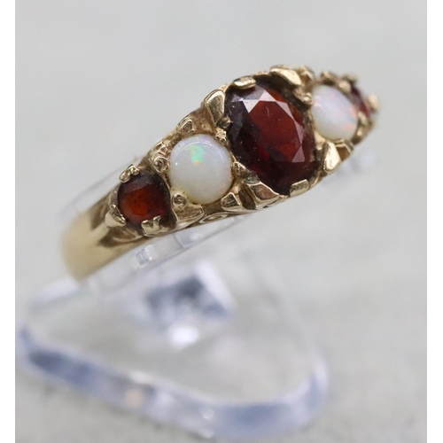 391 - A 9ct gold ladies' ring set with 3 garnets interspersed by 2 opals, Size O/P, 2.8 grams gross