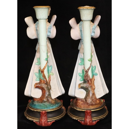 4 - A pair of Paris china figured candlesticks in the form of fairies, on round black bases, 34.5cm high... 