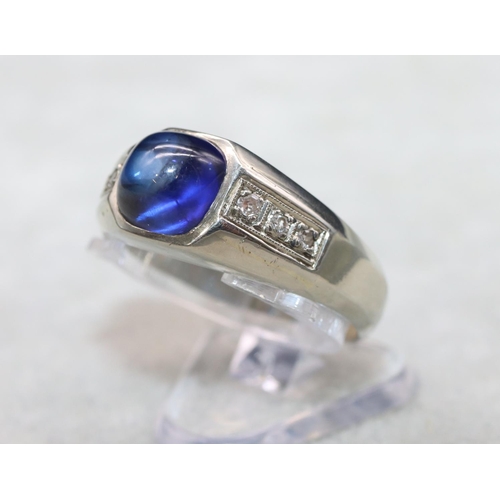 404 - An 18ct white gold cabachon cushion cut blue stone ring mounted with small diamonds to shoulders, Si... 