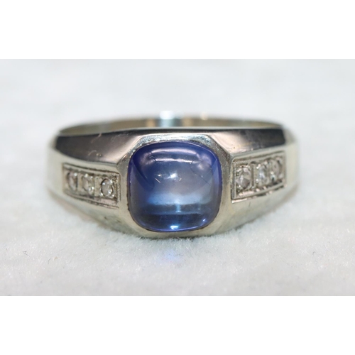 404 - An 18ct white gold cabachon cushion cut blue stone ring mounted with small diamonds to shoulders, Si... 