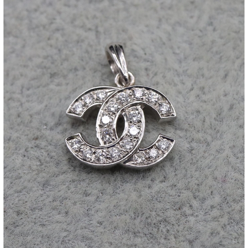 408 - An 18ct white gold pendant in the form of 2 entwined C's, inset with diamonds, 1.5cm high, 1.9 grams... 