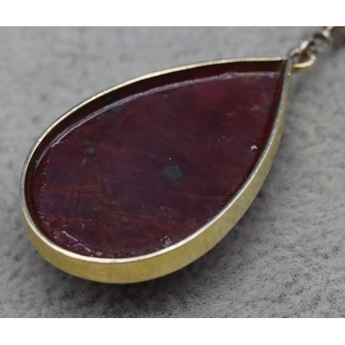 409 - A gold coloured metal drop natural ruby pear shaped pendant, mounted with small diamonds, 5cm high, ... 