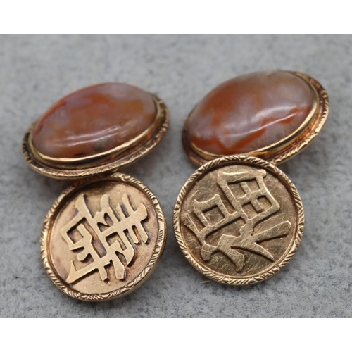 412 - A pair of Chinese gold and red jadeite oval gentlemen's cufflinks, 8.1 grams gross