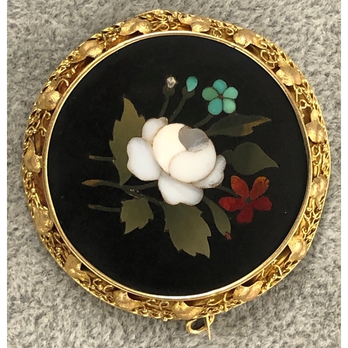 424 - A Pietra Dura circular brooch with floral decoration, in gold frame with raised leaf decoration (1 l... 