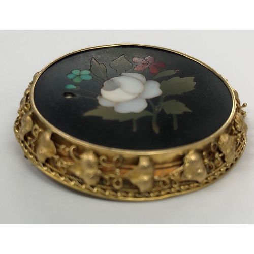 424 - A Pietra Dura circular brooch with floral decoration, in gold frame with raised leaf decoration (1 l... 