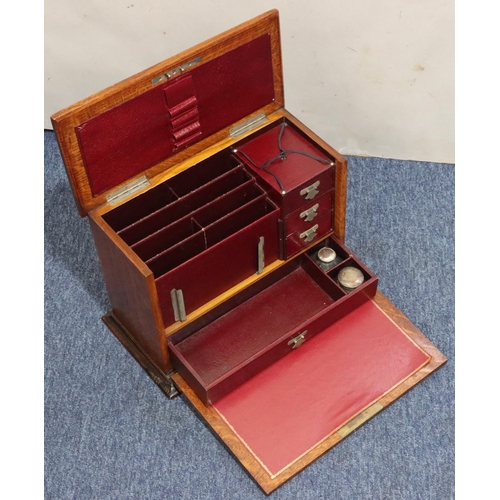 444 - An early 20th Century oak stationery box with hinged top and front enclosing red leather writing slo... 