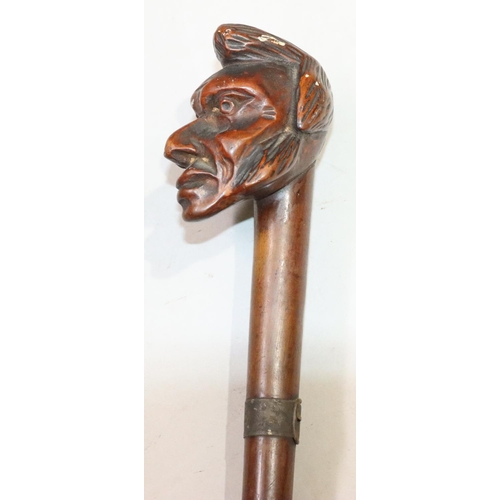 447 - A carved walking stick with figurehead motif, 86.5cm long overall