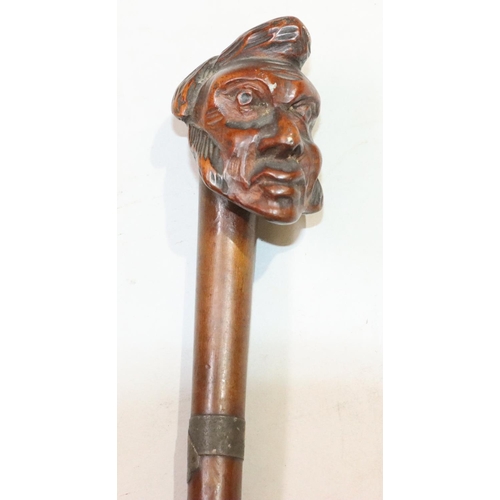 447 - A carved walking stick with figurehead motif, 86.5cm long overall