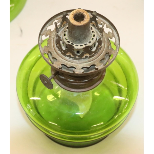 484 - A green glass oil lamp on round bulbous base with separate top, mounted with chimney and round bulbo... 