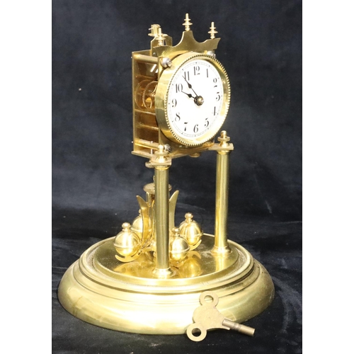 529 - A gilt metal Anniversary clock with circular white enamel dial and Arabic numerals, under glass dome... 