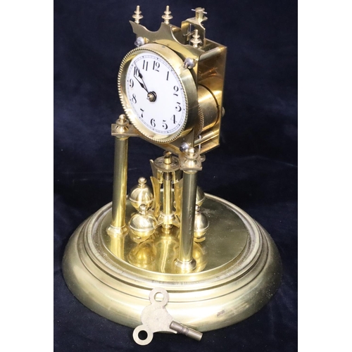 529 - A gilt metal Anniversary clock with circular white enamel dial and Arabic numerals, under glass dome... 