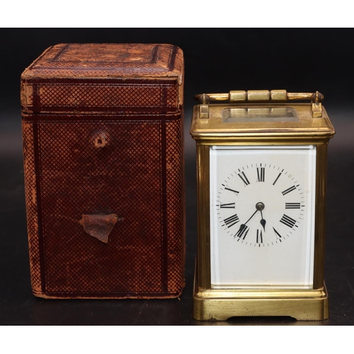 536 - A brass carriage clock with white enamel dial, Roman numerals and swing overhead handle, in fitted l... 