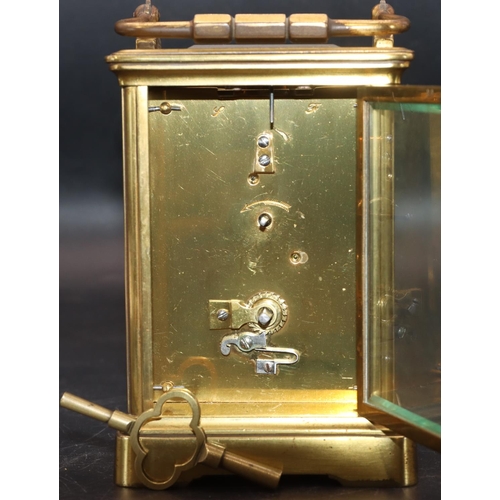 536 - A brass carriage clock with white enamel dial, Roman numerals and swing overhead handle, in fitted l... 