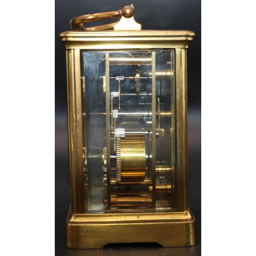 536 - A brass carriage clock with white enamel dial, Roman numerals and swing overhead handle, in fitted l... 