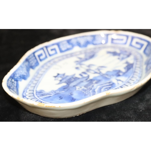 55 - An 18th Century Chinese blue and white rectangular scallop shaped dish with river landscape, buildin... 