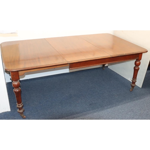 557 - A 19th Century mahogany draw leaf dining table with 1 extra leaf on round turned legs with brass toe... 