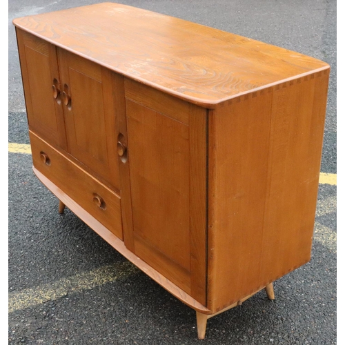 561 - A small Ercol elm mid Century sideboard, after Lucian Ercolani, with 3 panel doors, 1 drawer, on rou... 