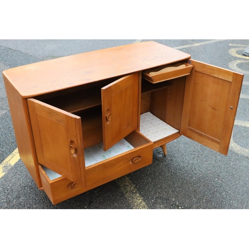 561 - A small Ercol elm mid Century sideboard, after Lucian Ercolani, with 3 panel doors, 1 drawer, on rou... 