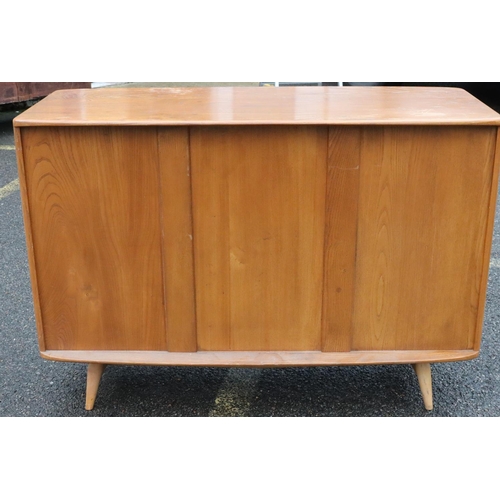 561 - A small Ercol elm mid Century sideboard, after Lucian Ercolani, with 3 panel doors, 1 drawer, on rou... 