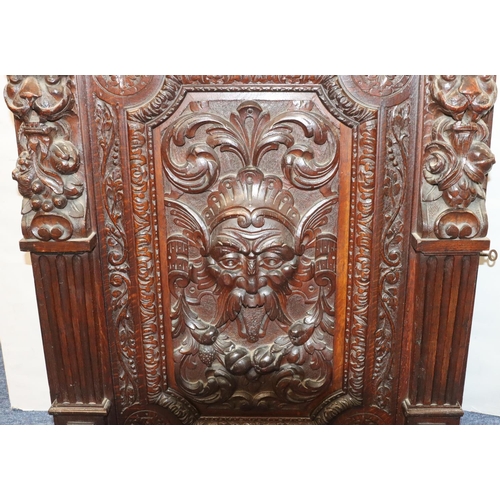 564 - A Victorian carved oak hanging cabinet with single door with carved mask head, fruit, leaf, scroll a... 