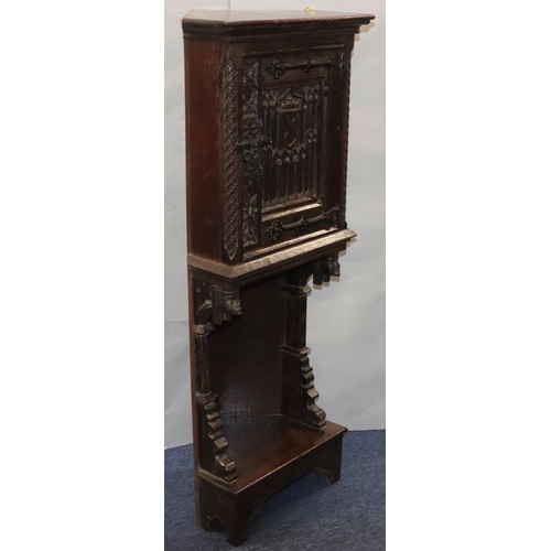 566 - A Victorian oak small low corner cupboard with single panel door with carved crest, figurehead and f... 