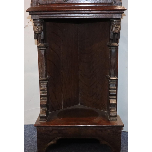 566 - A Victorian oak small low corner cupboard with single panel door with carved crest, figurehead and f... 