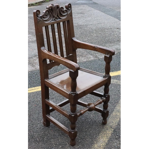 572 - An 18th Century oak narrow armchair with fluted stick back with carved scroll decoration, solid seat... 