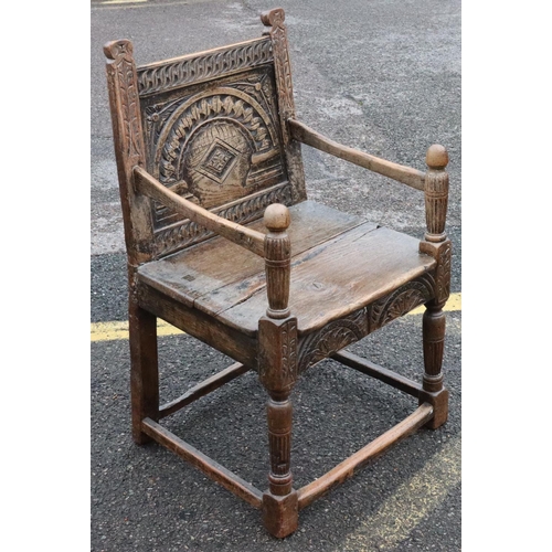 573 - An early oak armchair with carved panel back, bulbous fluted arm supports, solid 2-planked seat with... 