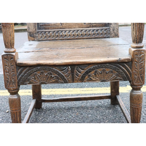 573 - An early oak armchair with carved panel back, bulbous fluted arm supports, solid 2-planked seat with... 