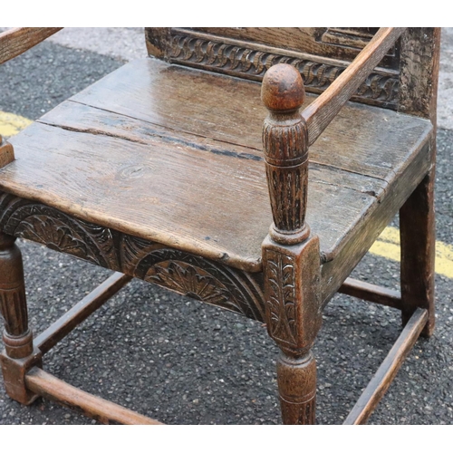 573 - An early oak armchair with carved panel back, bulbous fluted arm supports, solid 2-planked seat with... 