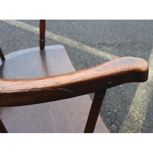 575 - A primitive Welsh stick back armchair with early metal supports to back, thick solid seat, on splaye... 