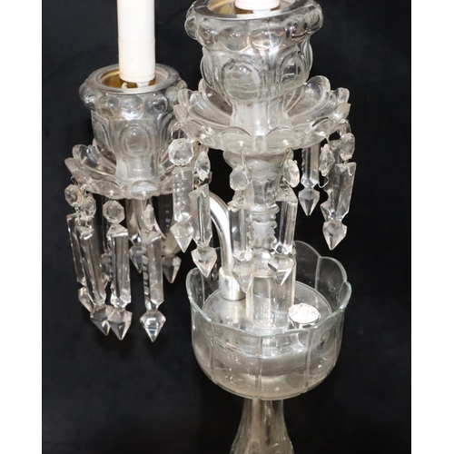 73 - A cut glass 2-branch, 3-light candelabra with 3 trumpet shaped storm shades, on round sweeping base,... 