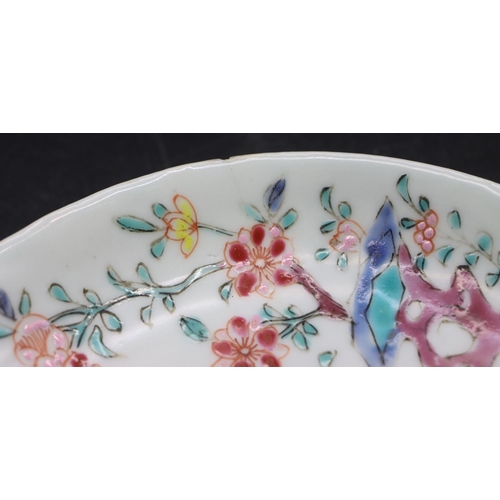 95 - A Chinese tea bowl and saucer on white ground with multi-coloured figure fence and floral decoration... 