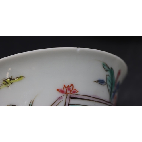 95 - A Chinese tea bowl and saucer on white ground with multi-coloured figure fence and floral decoration... 