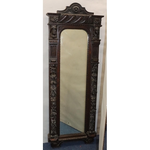 565 - A Victorian carved oak hall mirror with allover raised figurehead, fruit, leaf, scroll and thumb pat... 