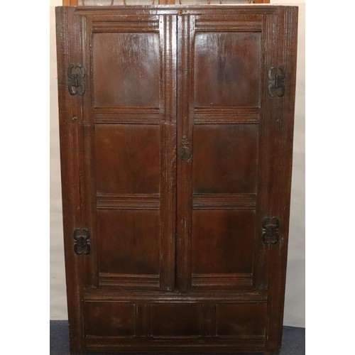 574 - An 18th Century oak cupboard with 2 triple panel doors enclosing hanging pegs, triple panel below, 1... 