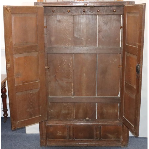 574 - An 18th Century oak cupboard with 2 triple panel doors enclosing hanging pegs, triple panel below, 1... 