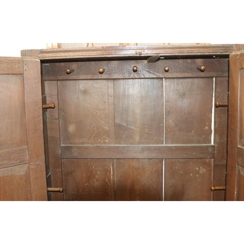 574 - An 18th Century oak cupboard with 2 triple panel doors enclosing hanging pegs, triple panel below, 1... 