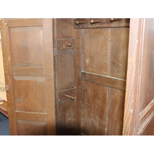 574 - An 18th Century oak cupboard with 2 triple panel doors enclosing hanging pegs, triple panel below, 1... 