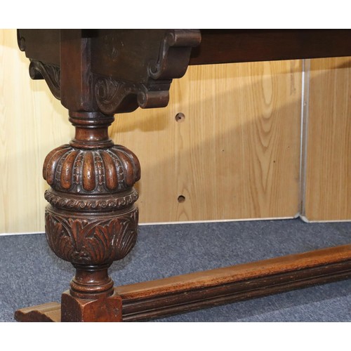 576 - A heavy carved oak refectory table with 2 bulbous supports with carved and leaf decoration, centre s... 