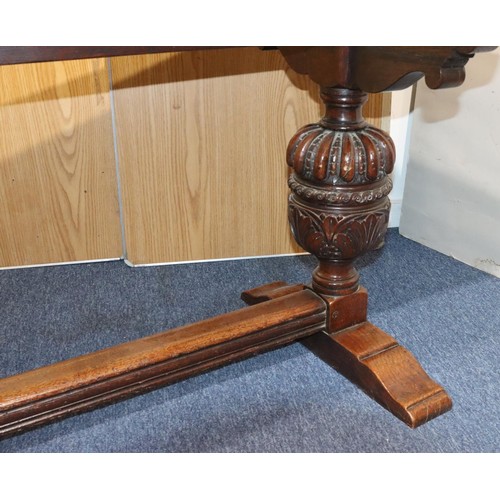 576 - A heavy carved oak refectory table with 2 bulbous supports with carved and leaf decoration, centre s... 